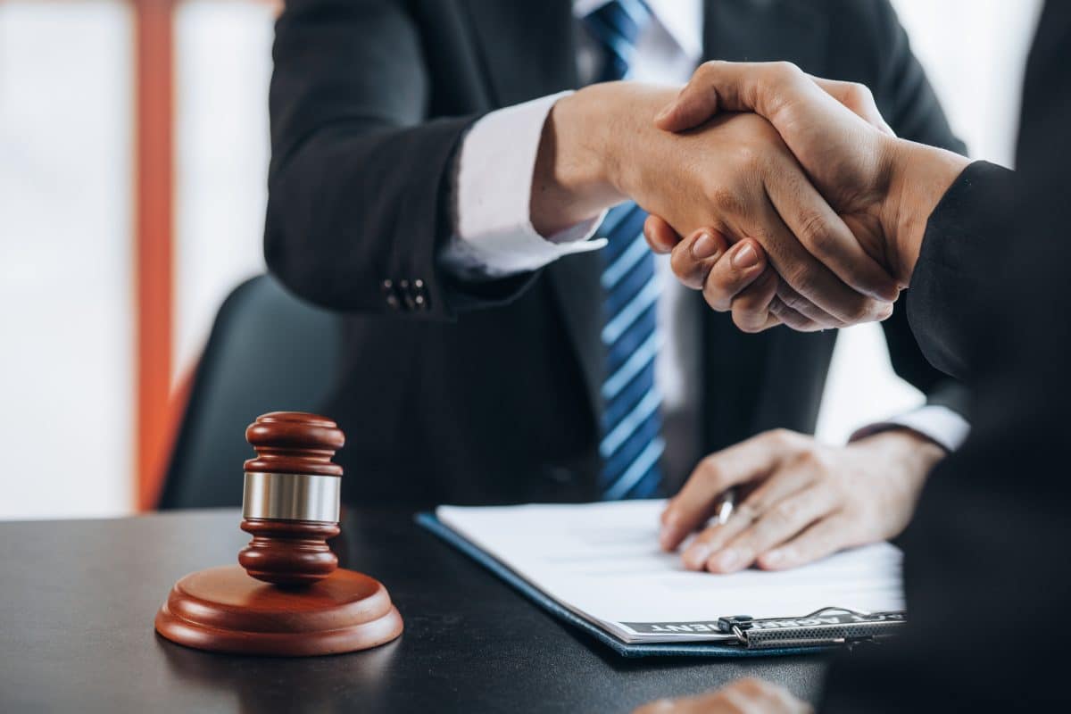 An experienced personal injury lawyer in Maine shakes hands with a client after agreeing to take on their case.