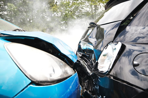 A blue car rear-ended another vehicle in a Maine car accident. Both vehicles are badly damaged.